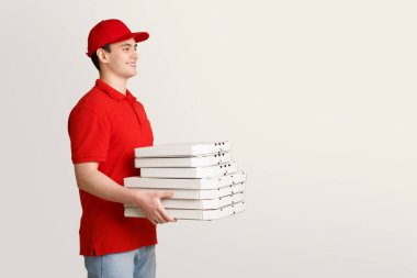Hızlı pizza teslimatı. Kuryenin elinde bir sürü pizza var.