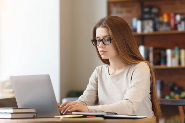 Portrét mladé dívky student sedí v kavárně s notebookem — Stock fotografie