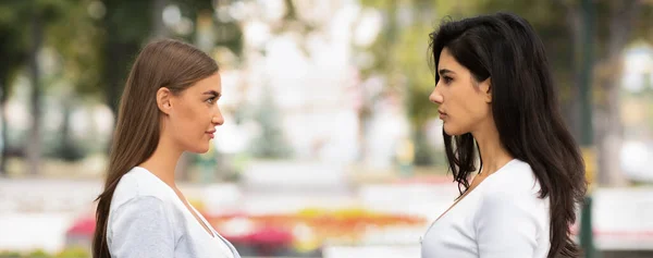 Duas meninas tendo confronto de pé fora no parque, Panorama — Fotografia de Stock