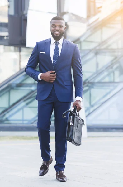 Веселий чорношкірий бізнесмен, який ходить надворі у міському районі — стокове фото