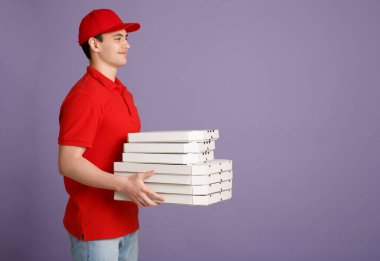 Popüler iş. Kırmızı üniformalı gülümseyen kurye pizza getiriyor.