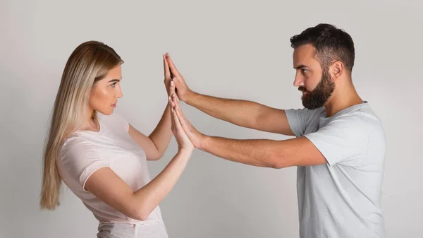 Enfrentarse a represor doméstico. Hombre presiona a mujer con sus manos, chica resiste — Foto de Stock