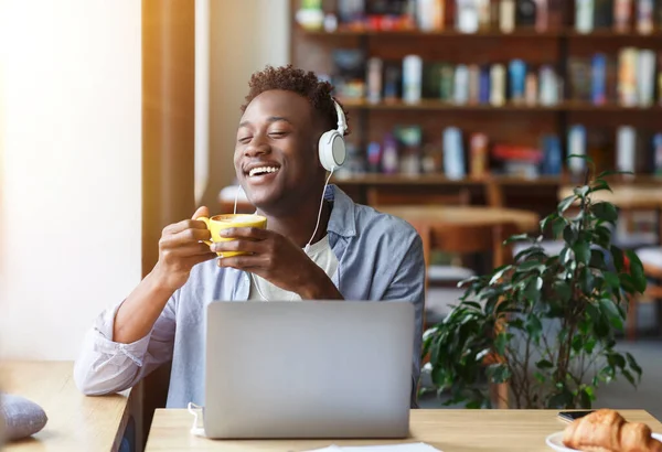 Alegre chico afroamericano disfrutando del café de la mañana mientras escucha música en la cafetería, espacio en blanco —  Fotos de Stock
