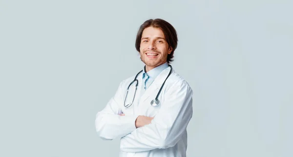 Steteskop ile arka planda poz veren yakışıklı tıp uzmanının portresi — Stok fotoğraf