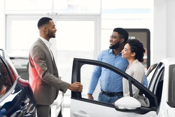 Autoverkäufer beraten Käufer und zeigen Luxus-Auto im Autohaus — Stockfoto