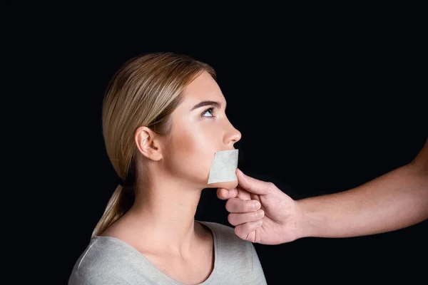 Discriminazione e tirannia. Uomo sigilli donna bocca con nastro adesivo — Foto Stock