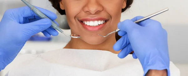 Hermosa sonrisa femenina y manos dentistas con herramientas — Foto de Stock