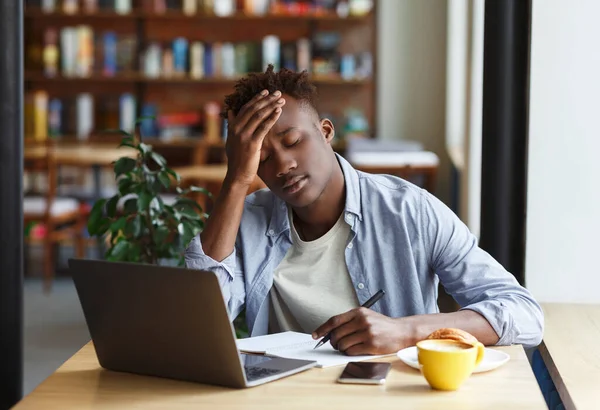 Vyčerpaný Afroameričan chlap studuje na zkoušku v kavárně — Stock fotografie