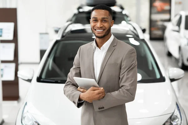 Smiling Dealer Standing Near Luxury Automobile Holding Folder In Showroom — Stock Photo, Image