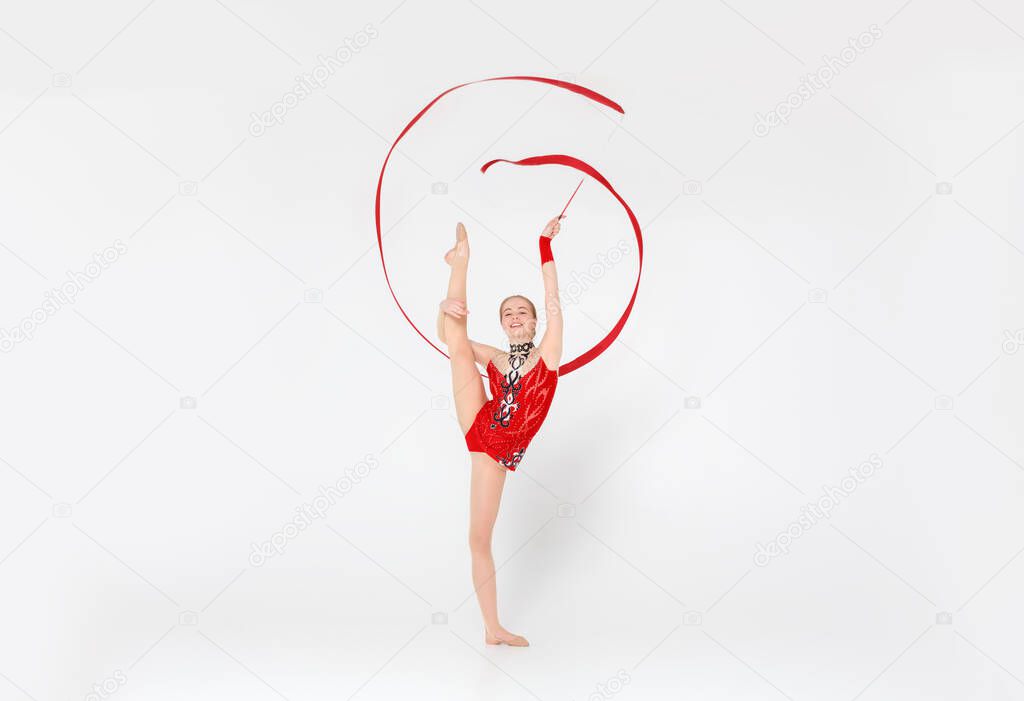 Beautiful millennial gymnast with string getting ready for sports competition, isolated on white