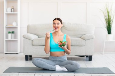 Neşeli Kadın Taze Sebze Salatasını Seviyor Zayıflatıyor ve İçerde Egzersiz Yapıyor