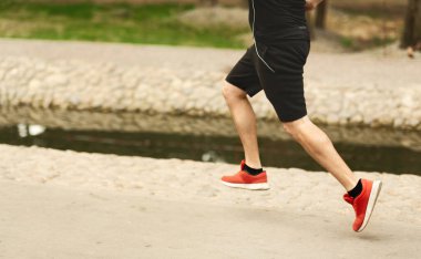 Parkta koşan sporcu, bacakların yan görünüşü