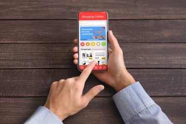 İnternette indirimli cep telefonu mağazası, online alışveriş için telefon kullanan adam.
