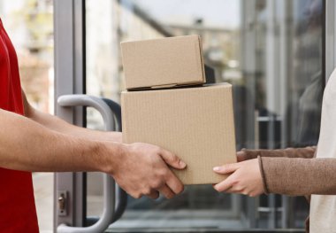 Mükemmel hizmet garantisi. Müşteri ve kuryenin ellerinde paketler var.