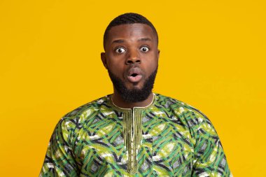 Sarı arka planda ağzı açık afrikalı bir adam.