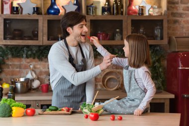 Salata pişirirken babayı ve küçük kızı sevmek.