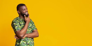 Meraklı siyah adam çenesine dokunuyor, fotokopi alanına bakıyor.