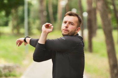 Çalışmadan önce el ve omuz geren sağlıklı bir adam.
