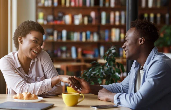 Jovem casal afro-americano de mãos dadas à mesa no café — Fotografia de Stock