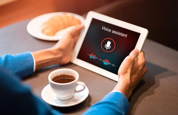 Man Holding Tablet Using Voice Assistant Sitting In Cafe, Cropped