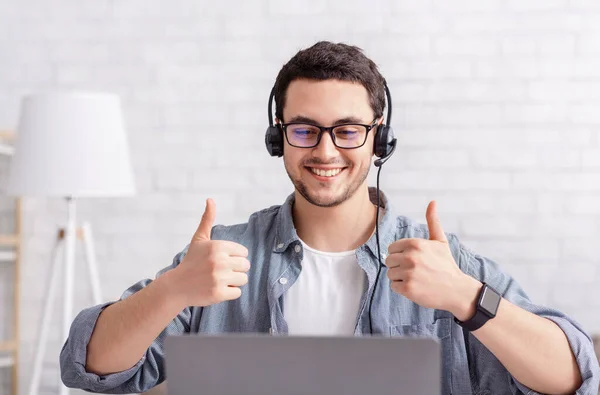 Online werk. Glimlachende man met headset shows teken uitstekend met de hand — Stockfoto