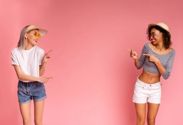 Oferta de verão. Meninas milenares alegres em desgaste elegante apontando para o espaço de cópia — Fotografia de Stock