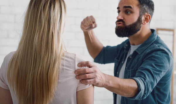 Violencia en la familia. hombre enojado balancea el puño a la mujer —  Fotos de Stock