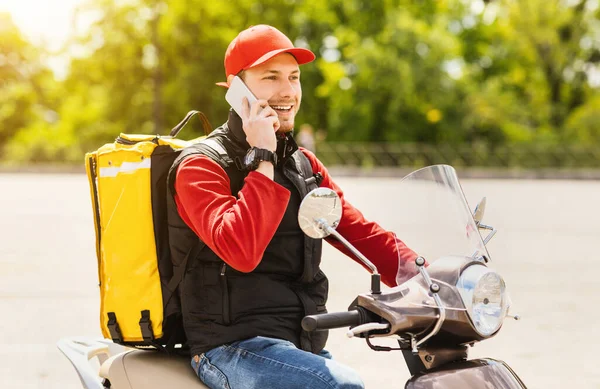 Kurierfahrer telefoniert mit Essenslieferung auf Motorroller im Freien — Stockfoto