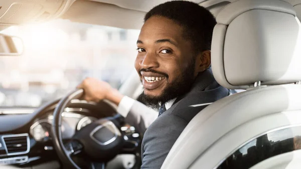Homme noir gai conduisant une automobile assis dans le siège des conducteurs, Panorama — Photo
