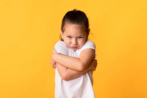 Young sad girl looking at camera with crossed arms — Stock Photo, Image