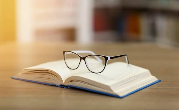 Aufgeschlagenes Buch hautnah mit Brille und Sonnenlicht — Stockfoto