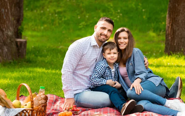 Lyckliga föräldrar med sin lille son på picknick i Green Park, kopiera utrymme — Stockfoto