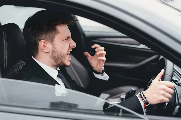 Wütender Geschäftsmann fährt in seinem neuen Auto — Stockfoto