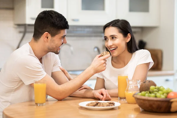 Smiling guy feeding his girl, couple having breakfast together — Stock Photo, Image