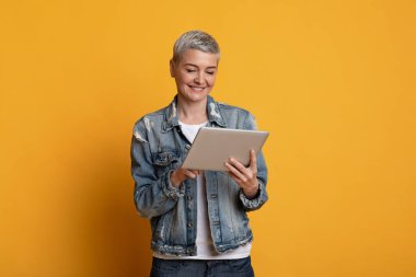 Harika bir uygulama. Dijital tablet kullanan orta yaşlı şık elbiseli güzel bir kadın.