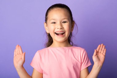 Asyalı kız heyecan içinde stüdyoda ellerini açıyor.