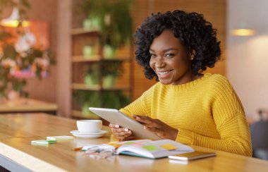 Sosyal medyayı dijital tablette kullanan neşeli Afrikalı kız