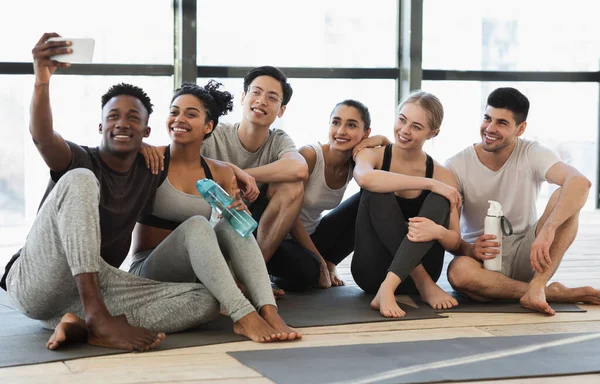 Felices amigos multiculturales tomando selfie en el teléfono inteligente después del entrenamiento de fitness —  Fotos de Stock