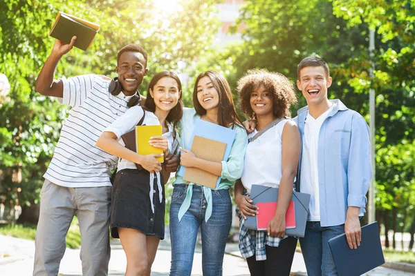 Grupo de estudantes universitários multiculturais posando ao ar livre após o estudo, sinceramente sorrindo — Fotografia de Stock