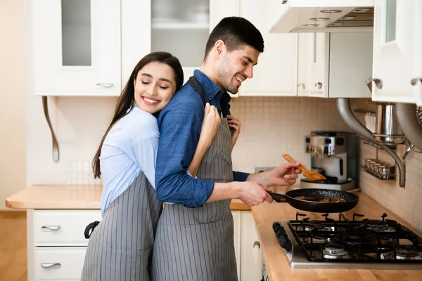 Loving couple preparing dinner frying meat on pan — Stock Photo, Image