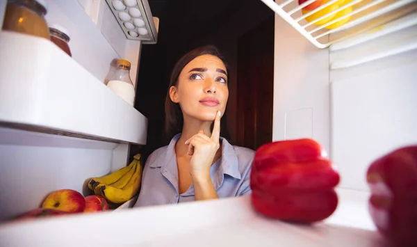 Umsichtige Hausfrau blickt in Kühlschrank, Blick von innen — Stockfoto