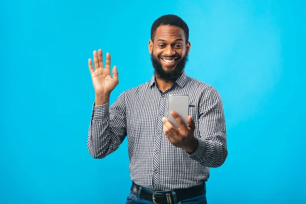 Feliz hombre negro usando el teléfono móvil en el estudio — Foto de Stock