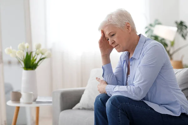 Mujer Climax. Retrato de una anciana deprimida sentada en un sofá en casa — Foto de Stock