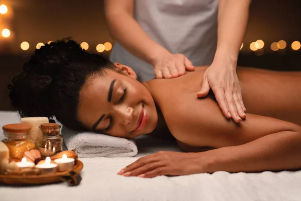 Fridfull afrikansk kvinna som har ryggmassage på orientaliska spa — Stockfoto