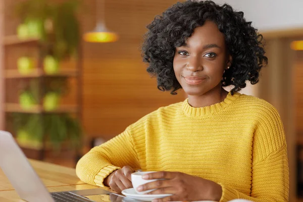 Jolie femme africaine regardant la caméra tout en buvant du thé — Photo