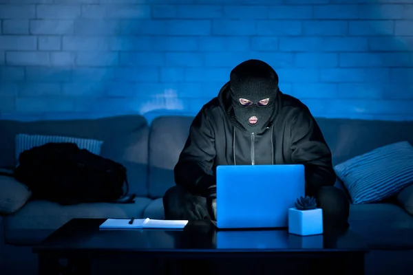 Hacker mascarado baixando informações privadas de um computador — Fotografia de Stock