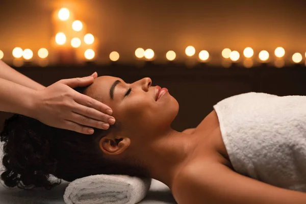 Peaceful black woman getting head massage at luxury spa — Stock Photo, Image