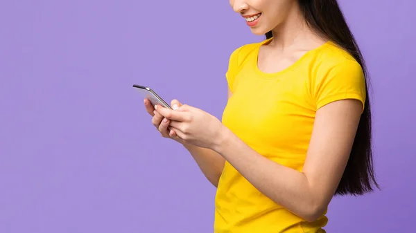 Neue nützliche Anwendung. Asiatisches Mädchen mit Handy auf lila Hintergrund, leerer Raum — Stockfoto