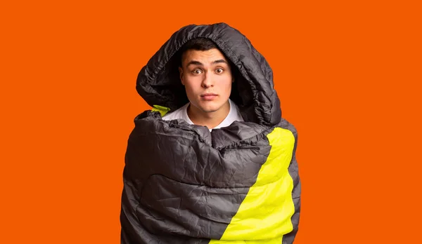 Испуганный парень в спальном мешке из-за апельсина — стоковое фото