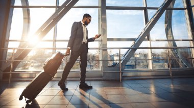 Siyah İşadamı Cep Telefonu Yürüyüşünü Havalimanı, Panorama, Yan Görünüm 'de Kullanıyor